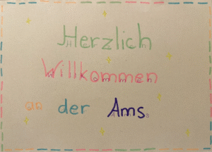 Ein handgeschriebener Willkommensgruß eines Schülers bzw. einer Schülerin für neue Mitschüler:innen. Zu lesen sind persönliche Wünsche zum Start an unserer Schule.