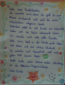 Ein handgeschriebener Willkommensgruß eines Schülers bzw. einer Schülerin für neue Mitschüler:innen. Zu lesen sind persönliche Wünsche zum Start an unserer Schule.