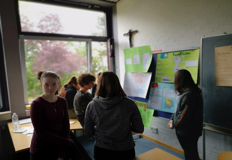 Schüler betrachten selbst erstellte Plakate
